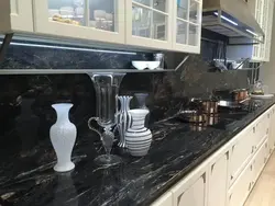 Kitchen with black countertop and marbled splashback photo