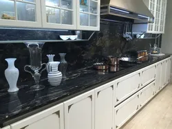 Кухня с черной столешницей и фартуком под мрамор фото