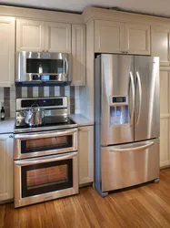 Kitchen design with built-in appliances and refrigerator photo