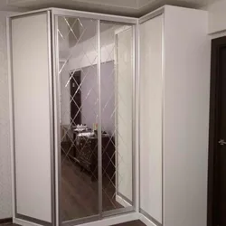 Photo of a corner wardrobe in the bedroom with a mirror