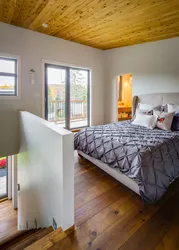 Дизайн спальни в доме с деревянным потолком