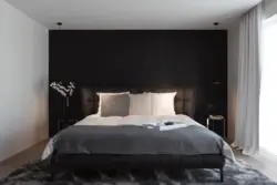 Интерьер спальни с темной стеной у кровати