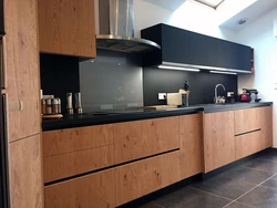 Wood kitchen with black countertop photo
