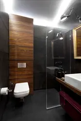 Bathroom design with dark tiles and wood