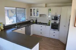 Дызайн кутняй кухні з ракавінай у акна