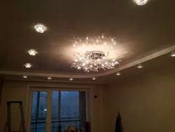 Ceiling with spotlights and chandelier in the living room photo