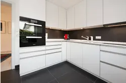 Kitchen with a black apron and countertop in a white interior