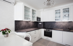 Kitchen With A Black Apron And Countertop In A White Interior