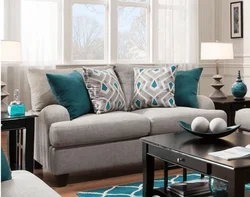 Серый диван с подушками в интерьере гостиной