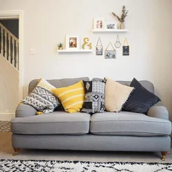 Серый диван с подушками в интерьере гостиной