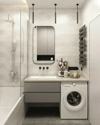 Interior of a small bath with sink and washing machine