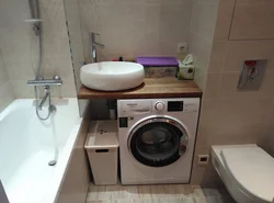 Interior of a small bath with sink and washing machine