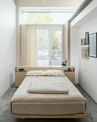 Bed by the window in the bedroom interior photo