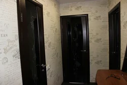 Wallpaper in the hallway with dark doors photo apartment