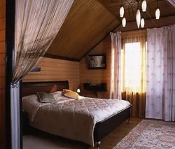 Дизайн спальни со скошенным потолком в деревянном доме