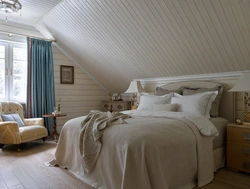 Bedroom design with a sloping ceiling in a wooden house