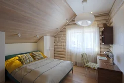 Дизайн спальни со скошенным потолком в деревянном доме