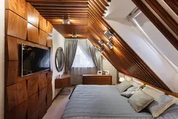 Bedroom design with a sloping ceiling in a wooden house