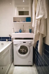 Вертикальная стиральная машина в интерьере ванной комнаты