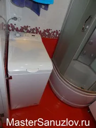 Vertical washing machine in the bathroom interior