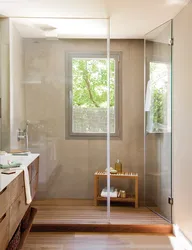 Pəncərəli bir evdə duşlu vanna otağı və tualetin dizaynı