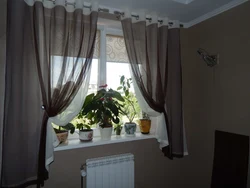 Curtains up to the windowsill in the living room interior