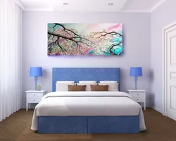 What kind of paintings are hung in the bedroom above the bed photo