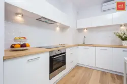 Белая кутняя кухня з драўлянай стальніцай фота