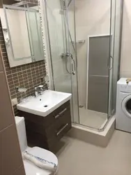 Showers and washing machines in a small bathroom photo