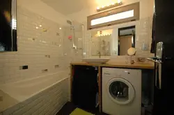 Photo of a bathroom countertop under the sink and washing machine