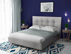 Photo of a bedroom with a soft headboard