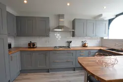 Светло серая кухня с деревянной столешницей фото