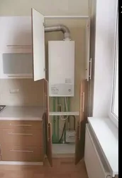 Photo of a kitchen with a gas boiler on the wall and pipes