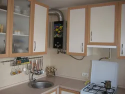 Photo of a kitchen with a gas boiler on the wall and pipes