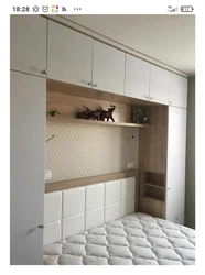 Wardrobes above the bed in the bedroom photo