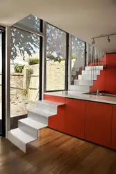 Kitchen in a house with stairs to the second floor design photo