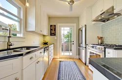Narrow kitchen design with window at end and door