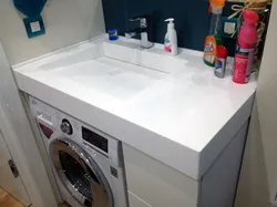 Washing machine under the sink in the bathroom photo