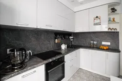 White kitchen with gray countertop and apron in the interior photo