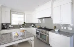 Белая кухня з шэрай стальніцай і фартухом у інтэр'еры фота