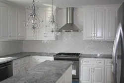 White kitchen with gray countertop and apron in the interior photo