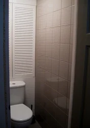 Louvered doors in the bathroom interior