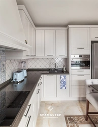 Black appliances in the interior of a light kitchen