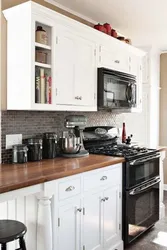 Black appliances in the interior of a light kitchen