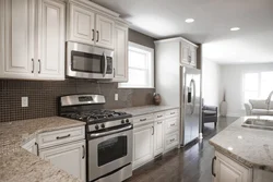 Black appliances in the interior of a light kitchen