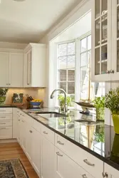 Kitchen design in a modern corner style with a window in the house