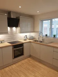 Kitchen design in a modern corner style with a window in the house