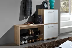 Shoe racks in the hallway with a seat and a drawer photo