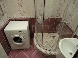 Bathroom with tiled shower and washing machine photo