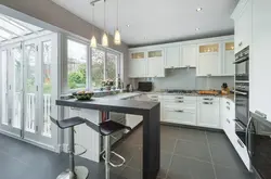 Photo of a kitchen in a house with a window and a bar counter